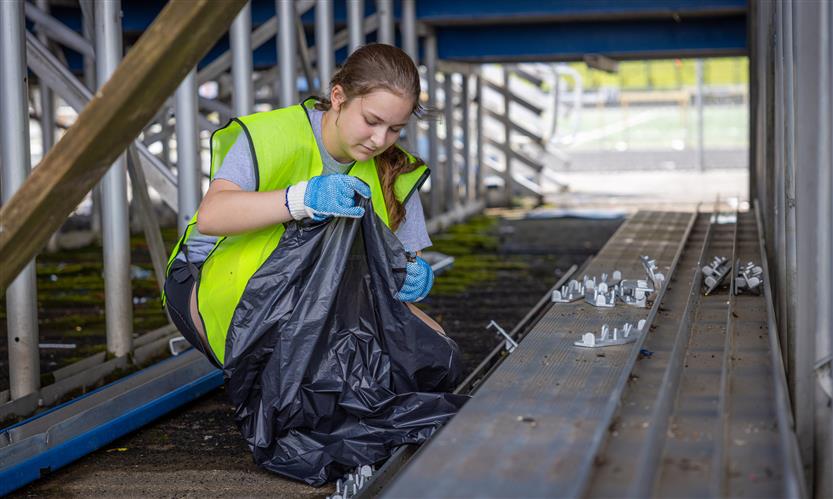 A Brentwood High softball cleans up under the bleachers